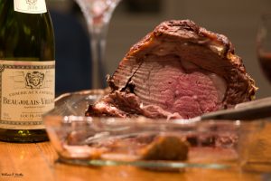 Prime rib sits beside a bottle of fine wine